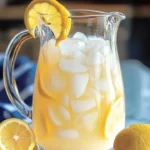 A refreshing glass of creamy lemonade with a slice of lemon on the rim