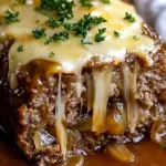Crockpot French Onion Meatloaf topped with melted Swiss cheese served on a plate