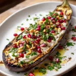 Deconstructed Baba Ghanoush platter featuring tahini, pomegranate, and pine nuts.