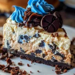 Delicious Cookie Monster Cheesecake topped with cookie pieces and a blue frosting glaze