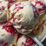 Homemade strawberry vanilla bean ice cream in a bowl with fresh strawberries