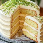 A slice of Key Lime Cake topped with cream cheese frosting on a decorative plate.