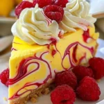 Luscious lemon raspberry swirl cheesecake garnished with fresh raspberries.