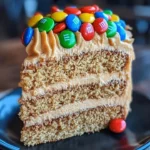 M&M's Peanut Butter Cake with Peanut Butter Frosting displayed on a cake stand