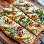 Pear, gorgonzola, and walnut flatbread on a wooden board