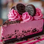 Delicious Pink Velvet Oreo Cheesecake topped with Oreo crumbs and pink frosting.