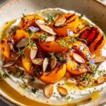 Plate of smoky stone fruit with herbed cheese, showcasing a delightful gourmet dish.