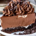 Delicious triple chocolate cheesecake topped with chocolate shavings and sauce.