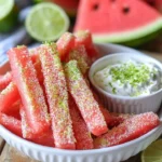 Watermelon fries served with coconut lime dip on a decorative plate.